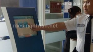 Satpam BCA memandu nasabah dengan mesin antrian